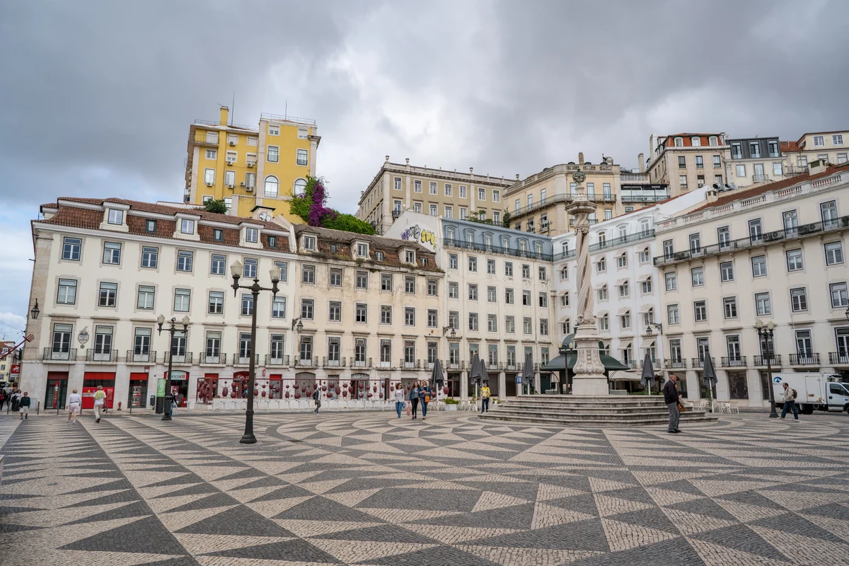 Black and white geometric stone paving around the pillory in Lisbon’s Praça do Município.