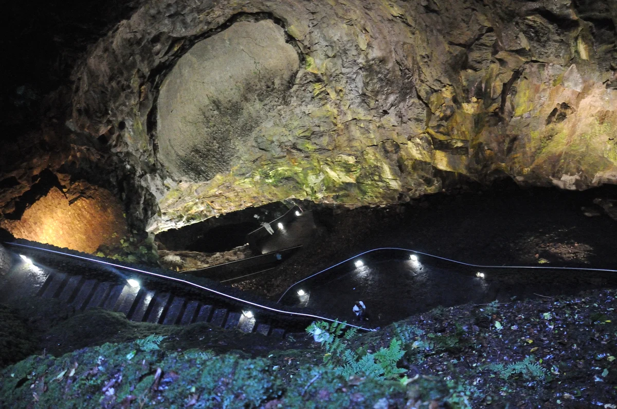 A steep stairway doubles back inside the volcanic cavity of Algar do Carvão.