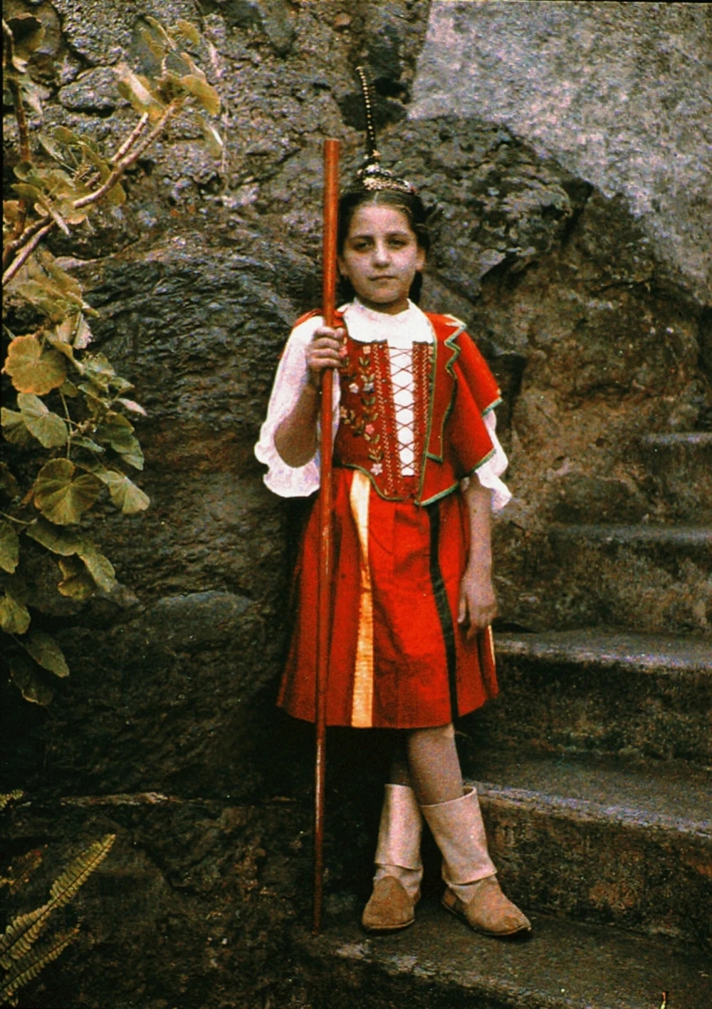 An early colour photograph shows a girl in a red Madeiran bodice and skirt with pale boots.